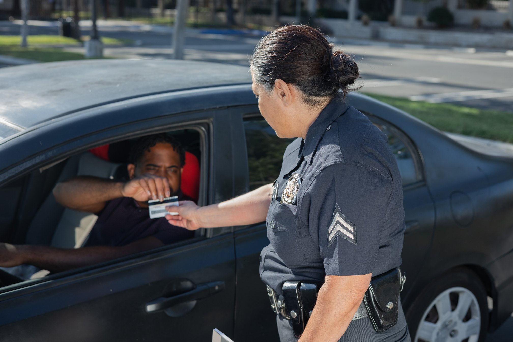 Man Giving His Driver's License to the Policewoman 